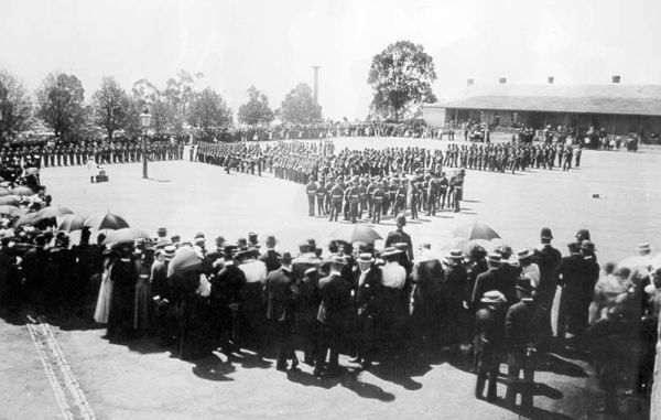 A crowd watches soldiers on parade in 1899, during the South African War 