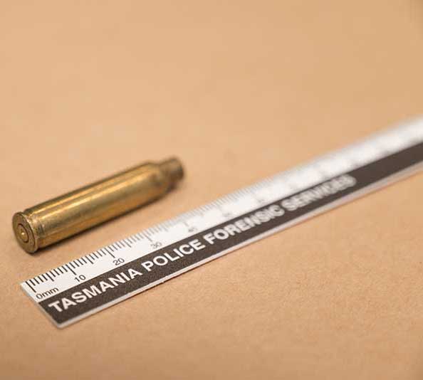 Bullet casing next to a Tasmania Police Forensic Services ruler for scale.