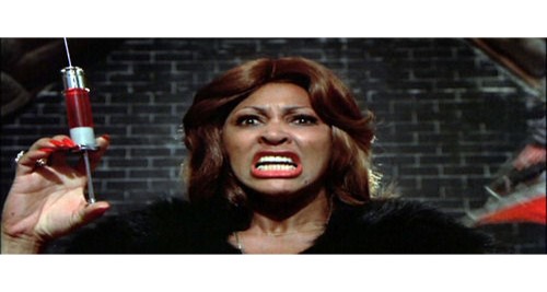 Tina Turner with syringe of red liquid- image from 'Acid Queen' video clip