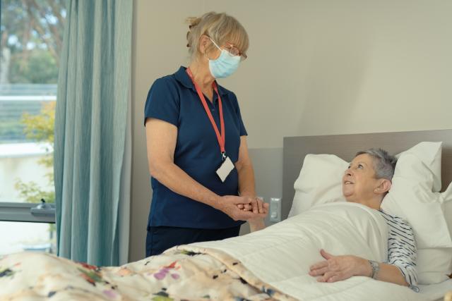 A nurse looks after a patient in an aged care facility.