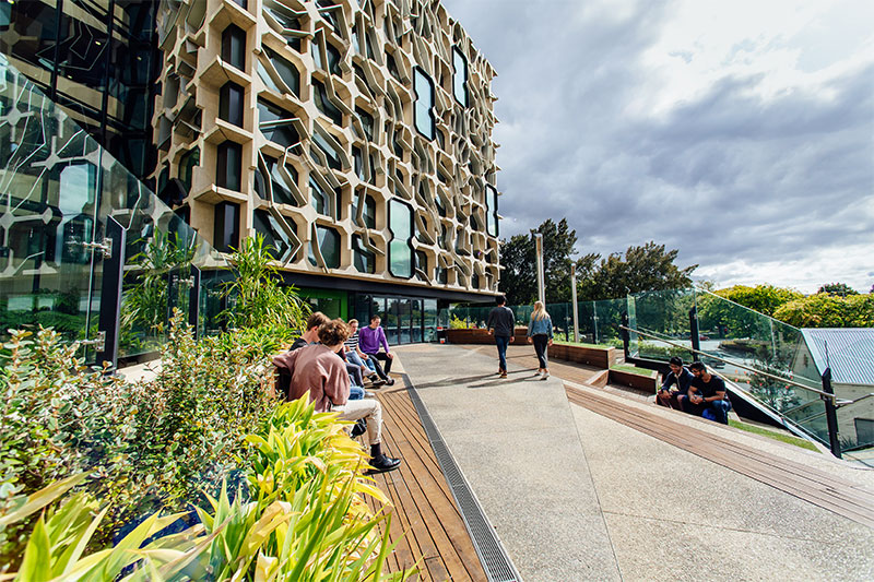 Stsudents enjoy the seated area outside the main entrance the Menzies building.