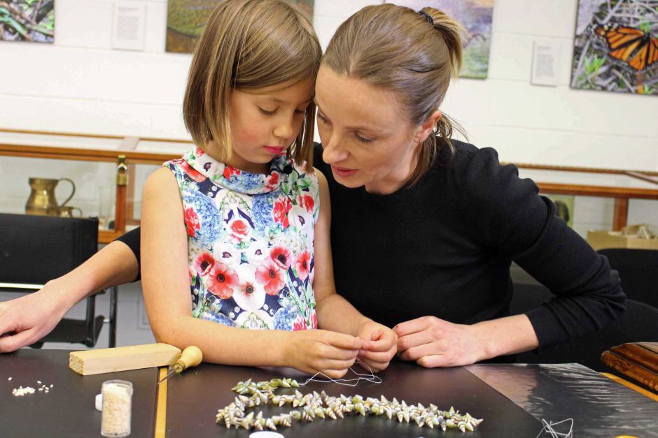 Zoe and her daughter, Eve, making a shell necklace. 