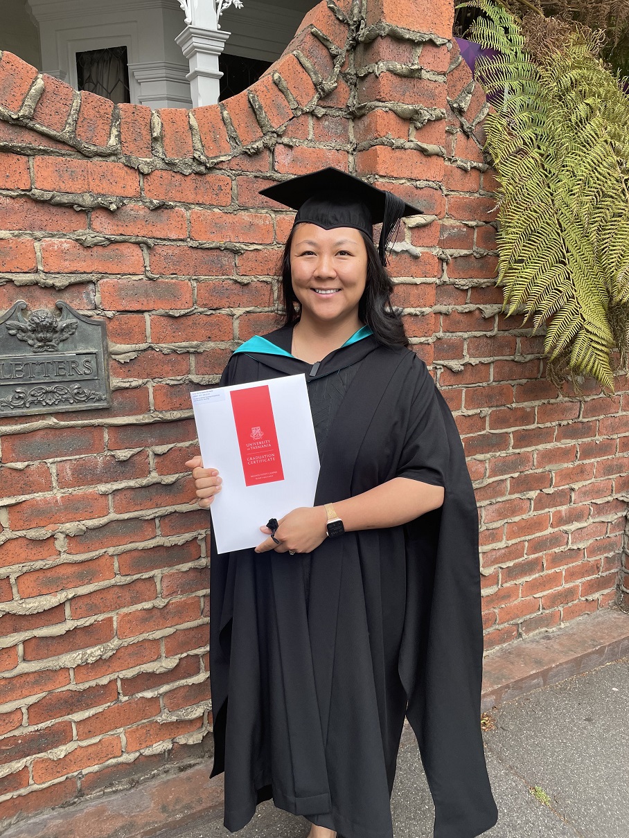 Tasmanian Registered Nurse Lucy Gardam in black academic dress, holding her testamur for one of her postgraduate qualifications. (Picture: supplied by Lucy Gardam)