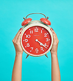 Photo of hands holding a clock