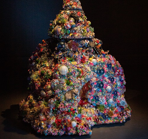 Image of Jacob Leary colourful sculptural work titled Exesssssscape. The artwork is made from mixed media and includes highly colourful plastic objects, beads and lights 
