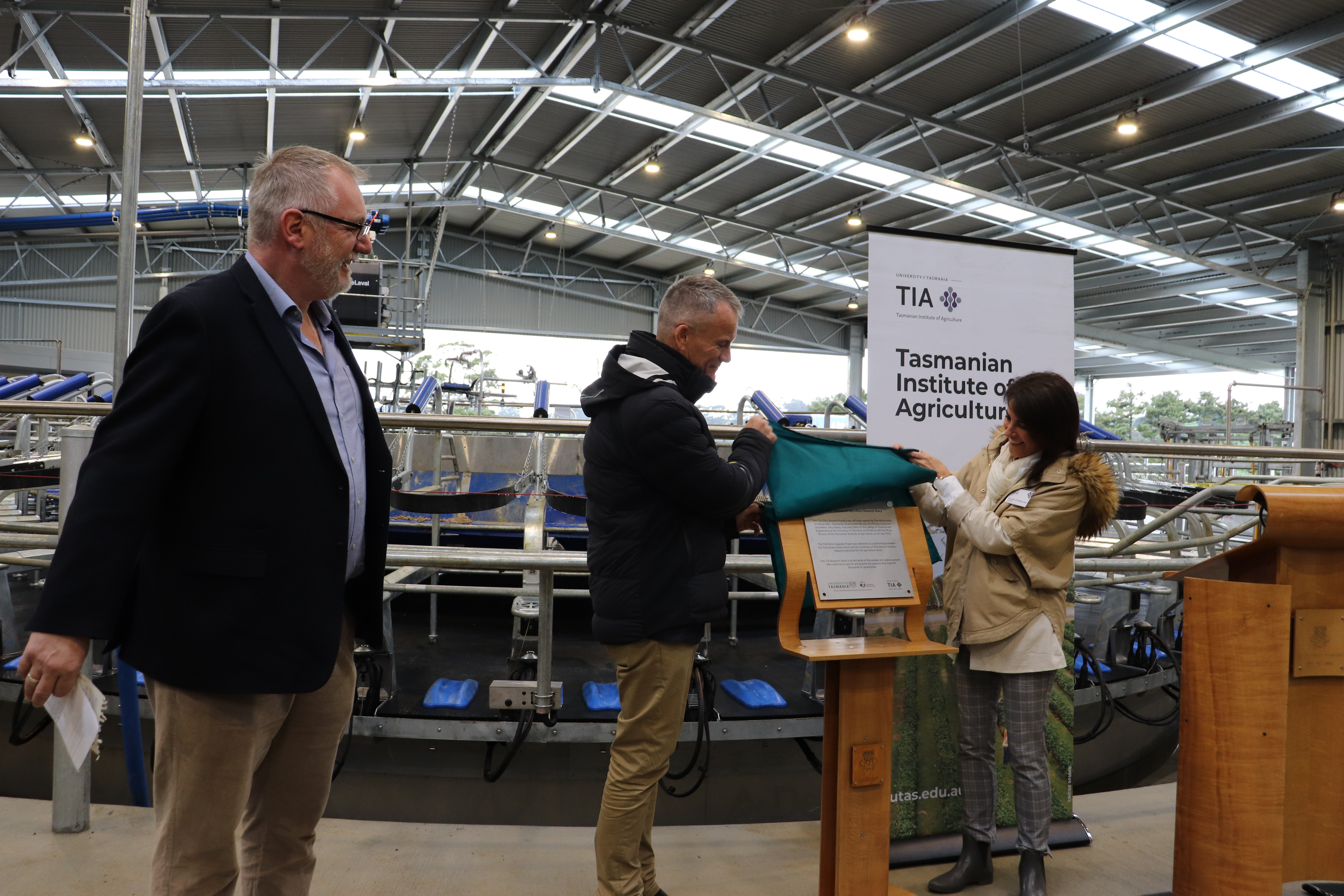 TIA Director Professor Mike Rose looks on as Terry Bailey, University of Tasmania Executive Dean - College of Sciences and Engineering, and the Honourable Jo Palmer Minister of Primary Industries and Water unveil the plaque at the new rotary dairy at TIA’s Dairy Research Facility at Elliott.