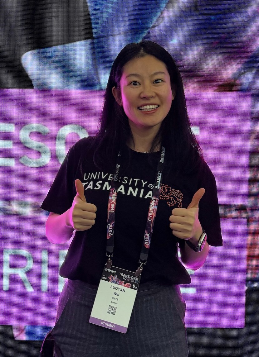 Student Luoyan Wei holds a certificate and stands in front of a banner which reads 'Society of Automotive Engineers - Australiasia'
