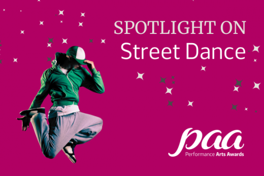 Hip hop dancer jumping in the air, wearing a hoodie and a cap pulled down to cover most of their face.